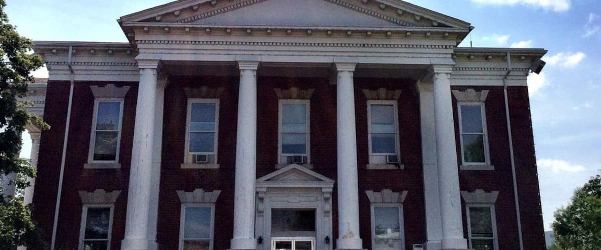 A large, red brick courthouse with white columns and a central pediment.