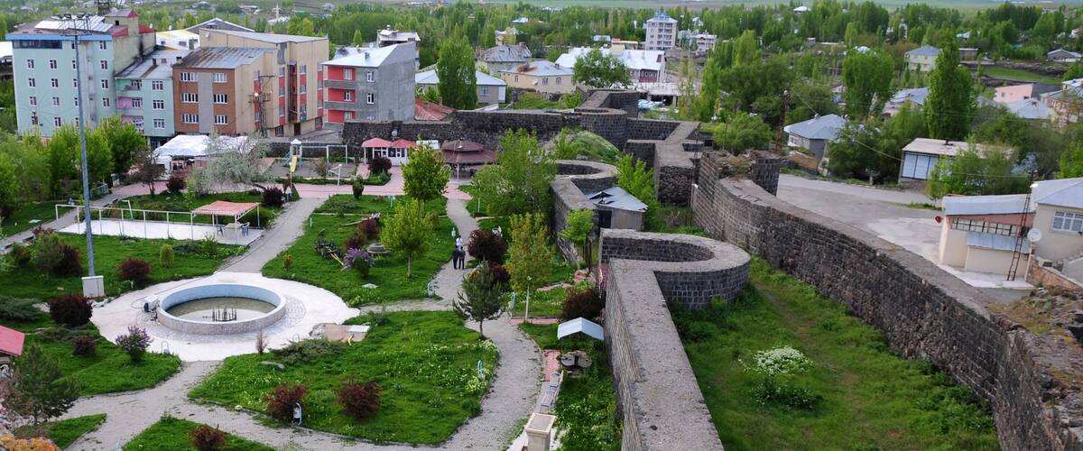 A historic fortification with a circular courtyard, surrounded by residential buildings and greenery.
