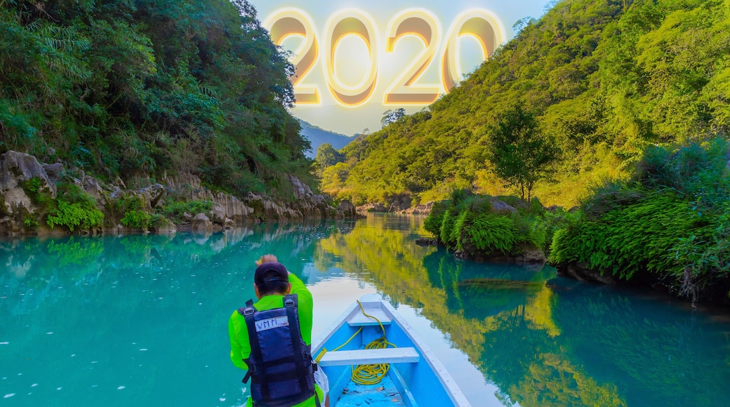 TAMUL, SAN LUIS POTOSI MEXICO - January 6, 2020: Rear view of man in raincoat and vest rowing in canoe. Active, adventure, outdoors, in tamul river