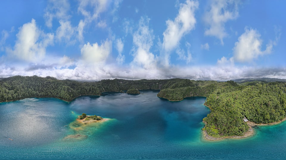 A coastal landscape with a large body of water, several small islands, and a forested area.