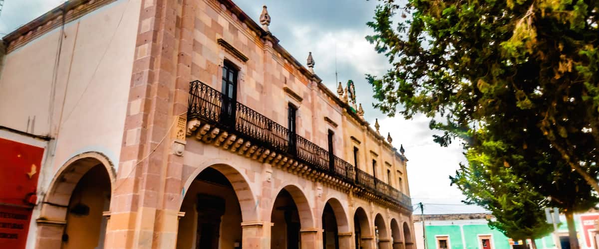 A historic building with arches and a balcony.