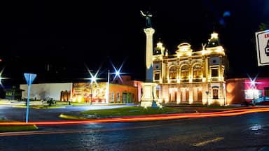 view of street at night with building illuminated, and lights of car in foreground, hidalgo theather in parral chihuahua