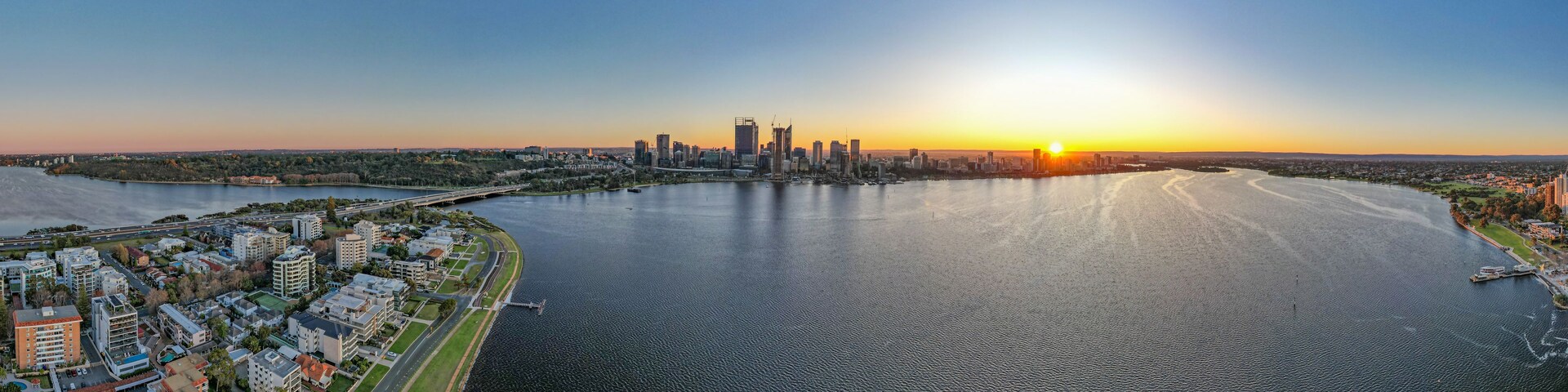 Un atardecer sobre el horizonte urbano con un río.