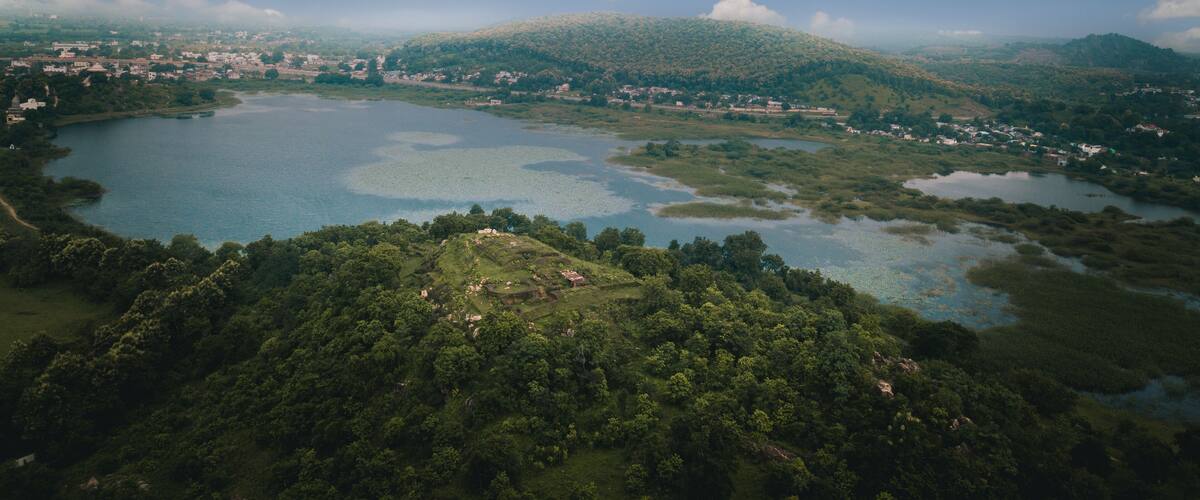 A lake surrounded by lush green hills and a small town.