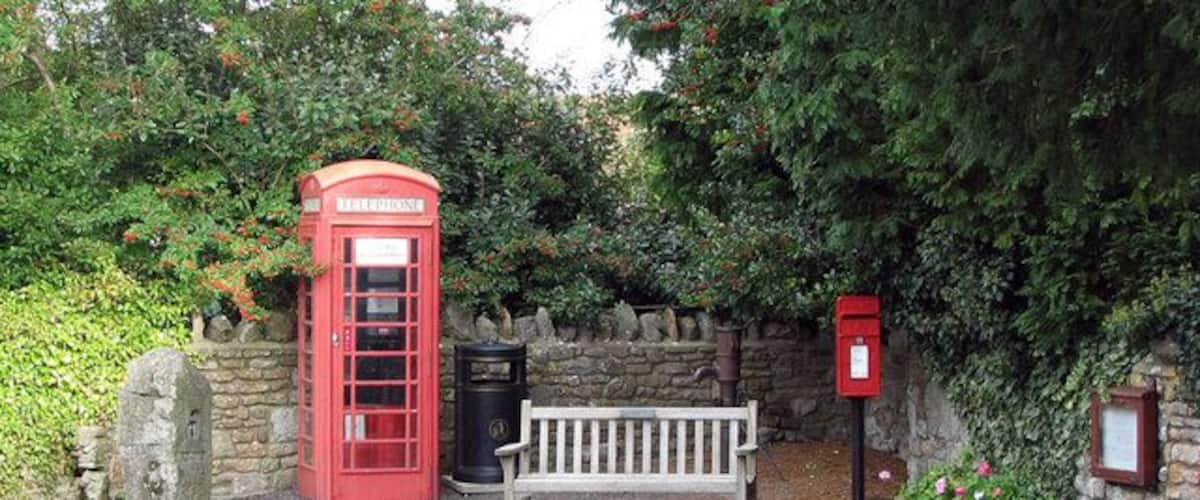 Convenient corner Tucked in a corner of the small village of Burrington, opposite the church. Here you can have a sit down, make a call, dispose of your rubbish, post a letter, pump some water, smell the flowers, appreciate modern art and organise your weekend via the notice board.