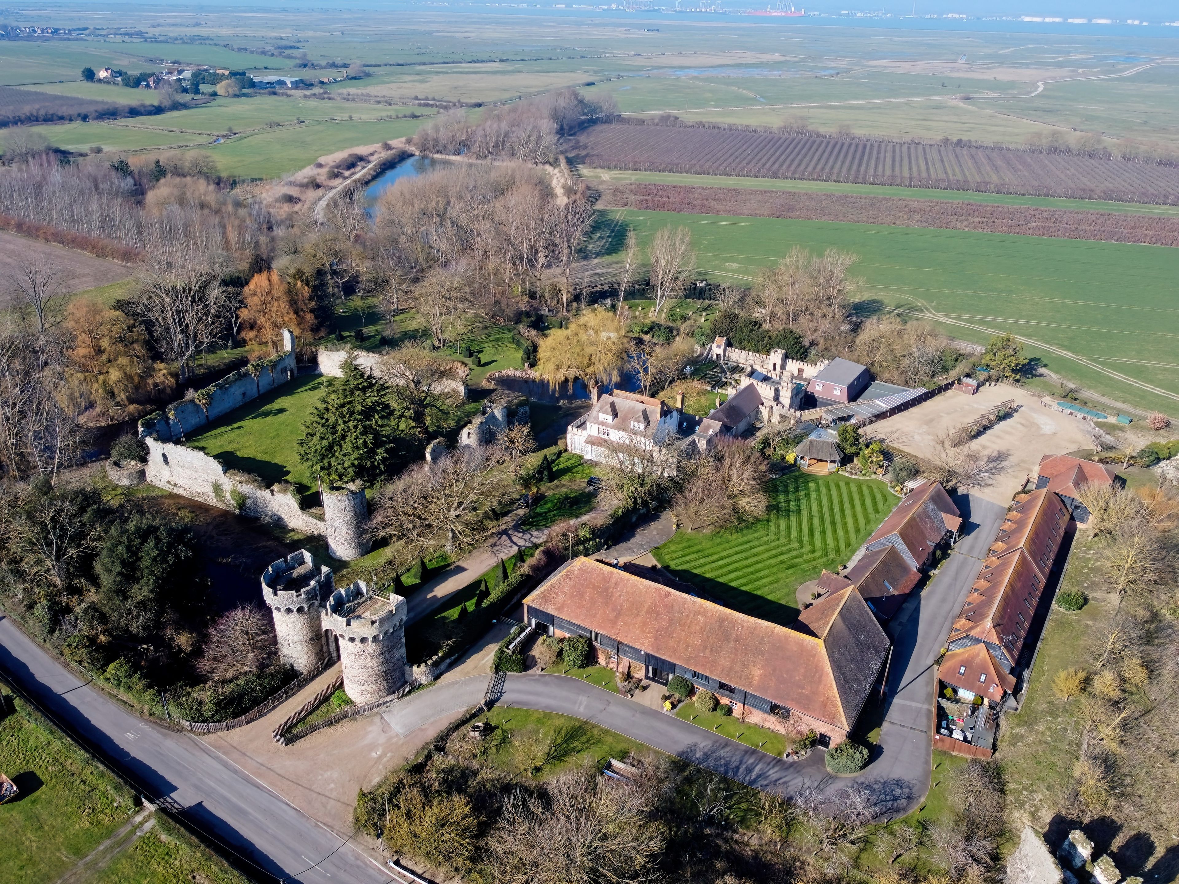 Vista aérea de una finca histórica con un castillo, una gran mansión y campos circundantes.