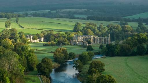 A castle surrounded by lush green fields and a river.