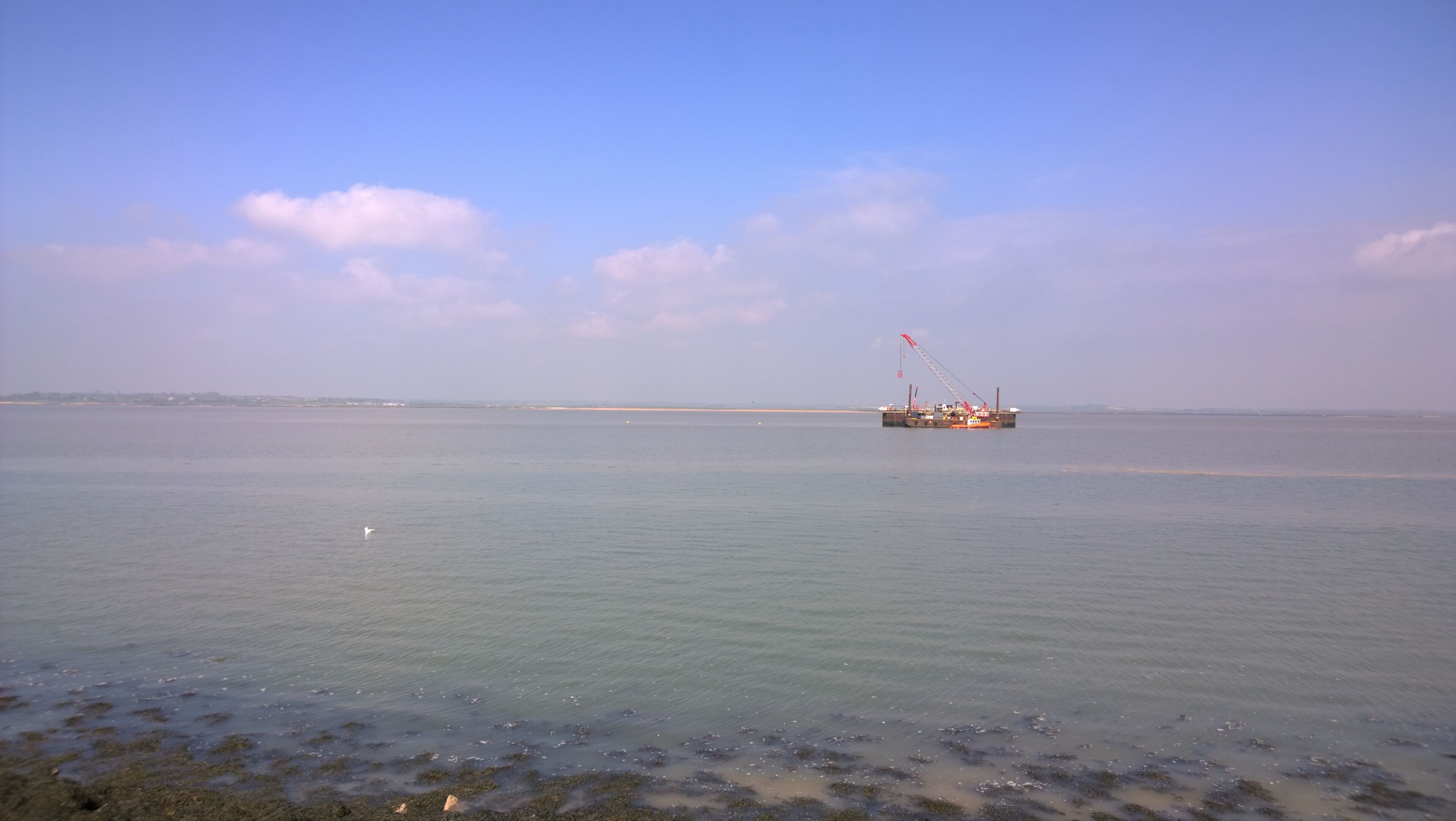A calm sea with a distant offshore platform.
