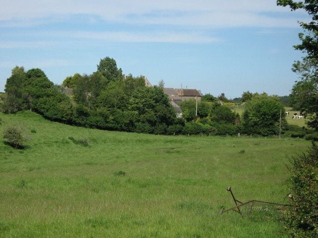 Lake Farm and cottages Valley with small meandering stream in foreground.