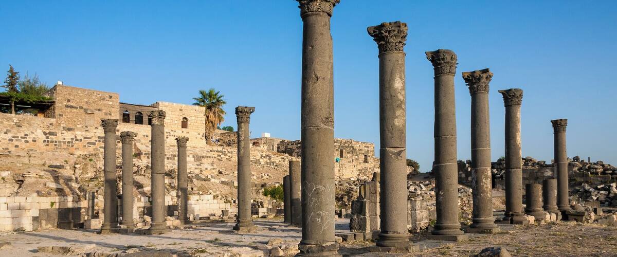 Ancient stone columns and ruins in a historical site.