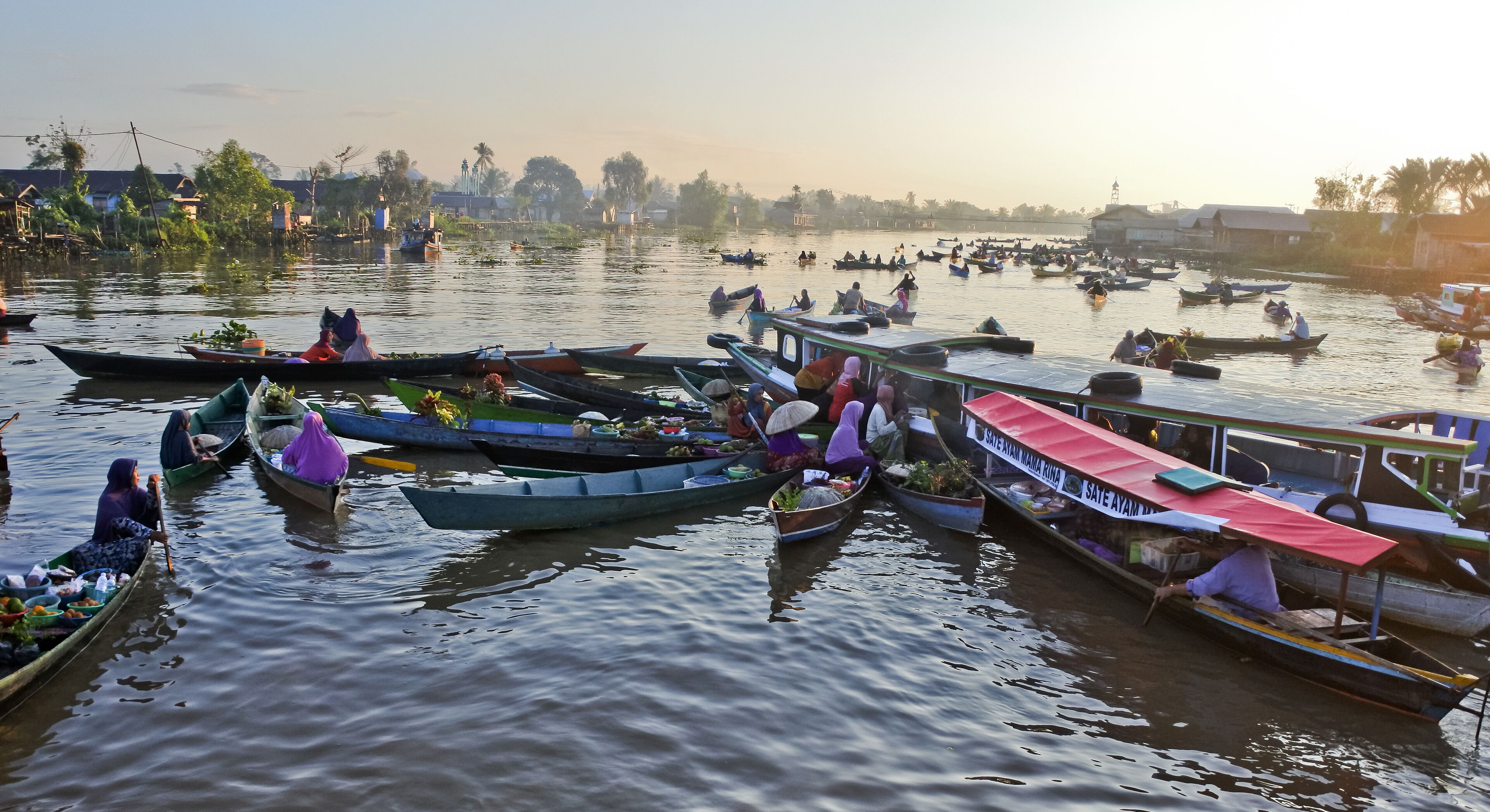 A busy river with numerous boats and people.