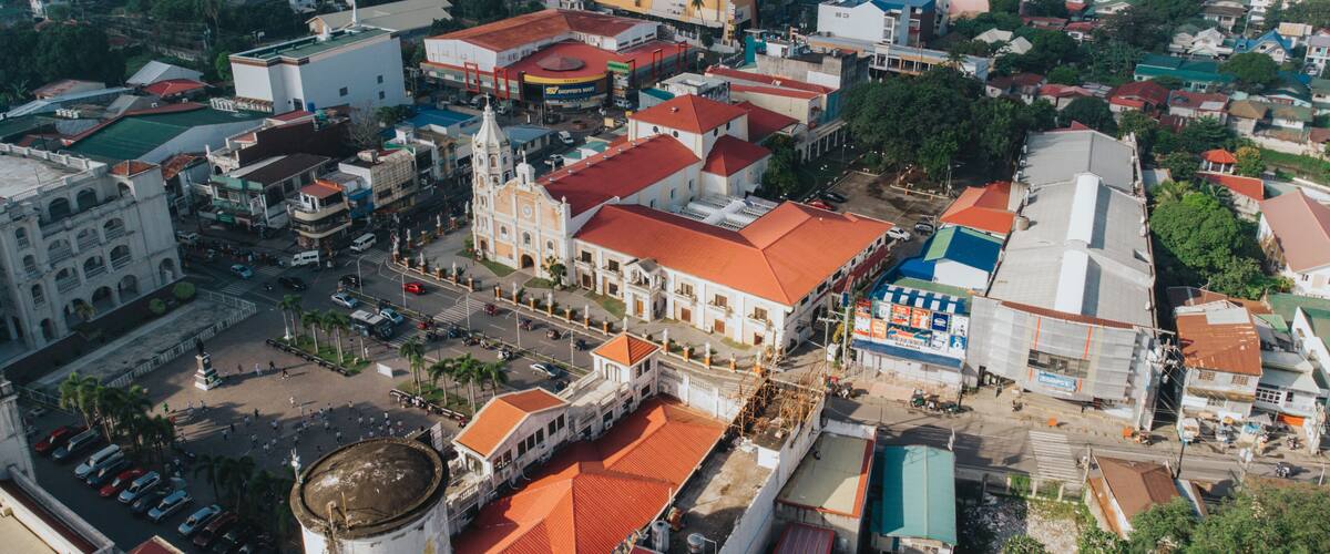 An aerial view of a town with a prominent church, a large water tower, and a mix of residential and commercial buildings.