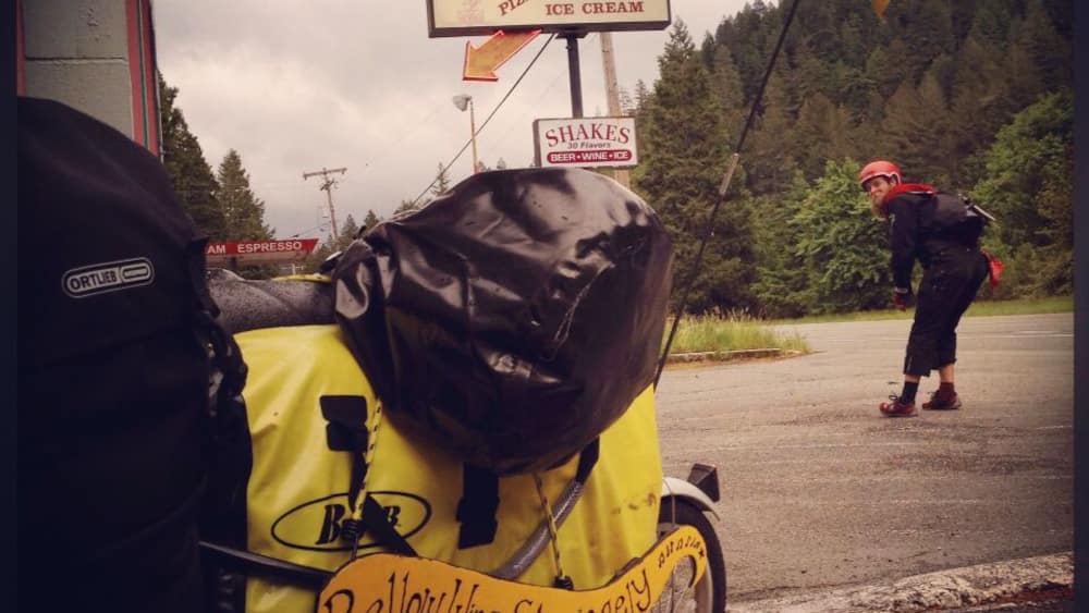 A bicycle with a yellow bag and a sign for a bicycle tour.