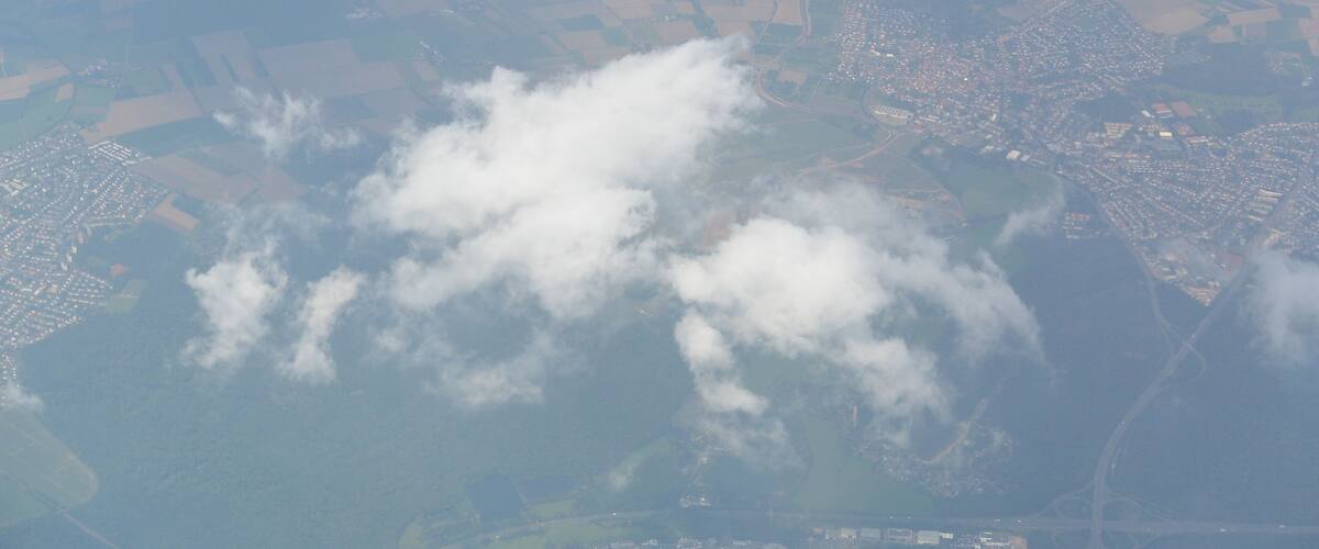 An aerial view of a landscape with fields, a town, and a body of water.