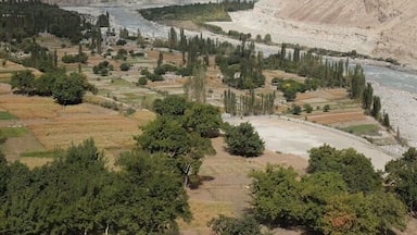 Un paysage montagneux avec une rivière, une végétation luxuriante et un ciel dégagé.