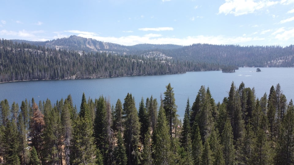 A lake surrounded by dense forests and mountains.
