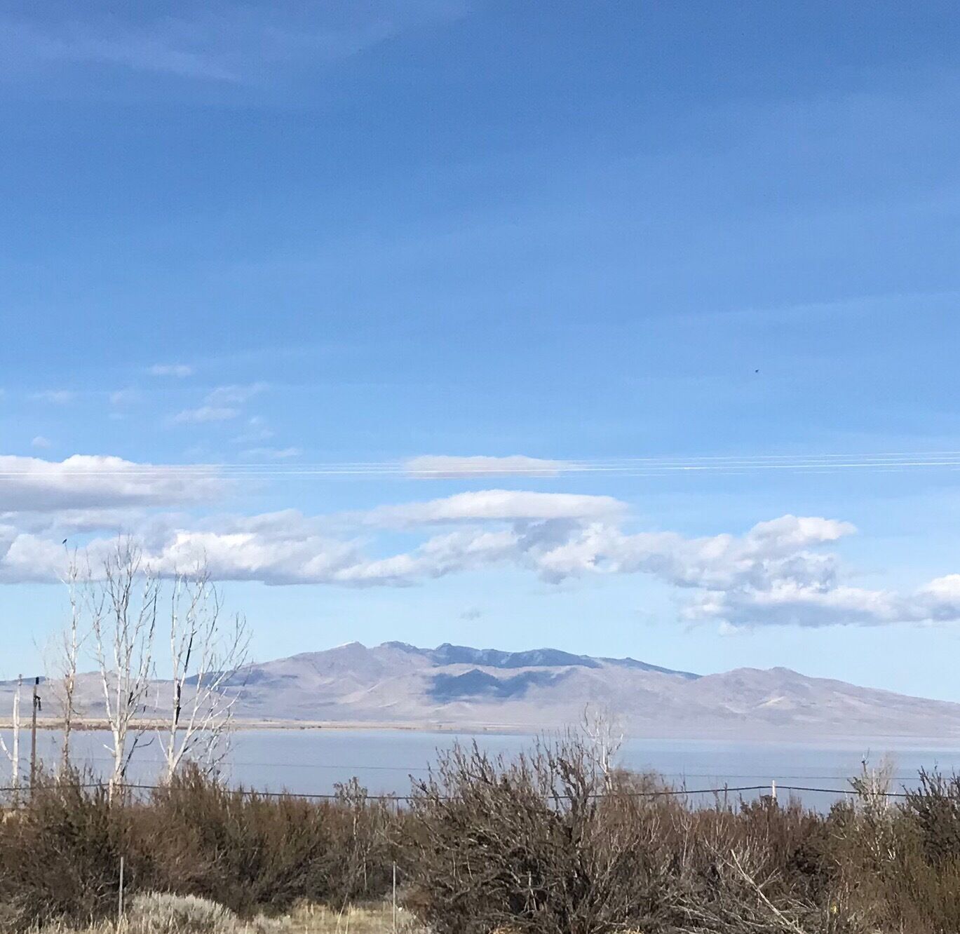 A clear sky, mountains, and a body of water.