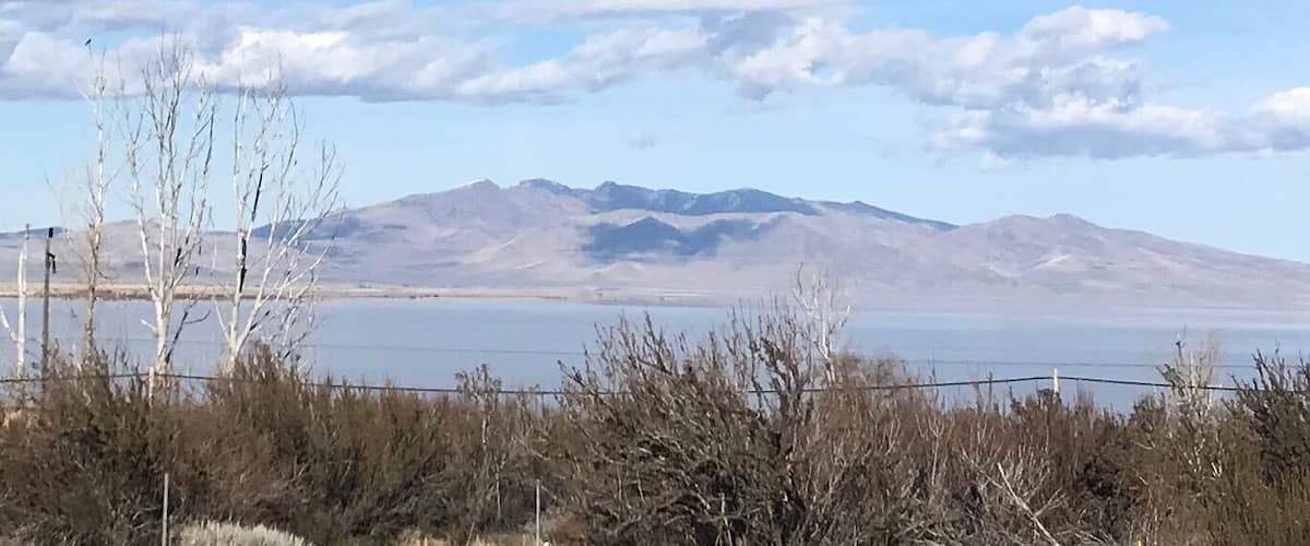 A clear sky, mountains, and a body of water.