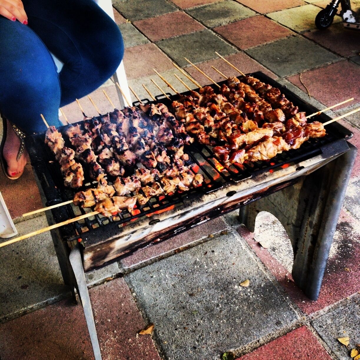 Not really a fancy restaurant. Just a family BBQ grilling an Indonesian dish known as Sate Babi. 