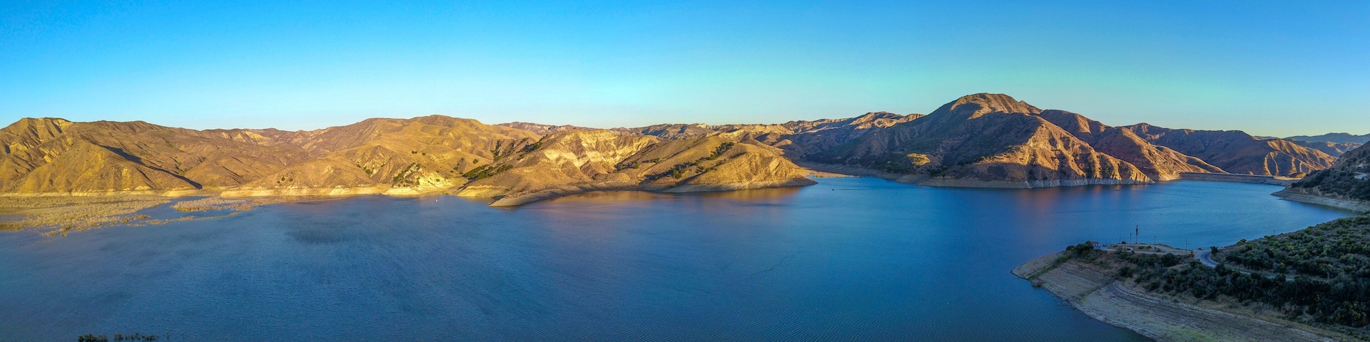 a stunning aerial shot of the deep blue lake water and mountains at Lake Piru in the Los Padres National Forest in California