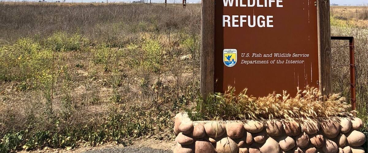 A sign for Pixley National Wildlife Refuge with a clear blue sky in the background.
