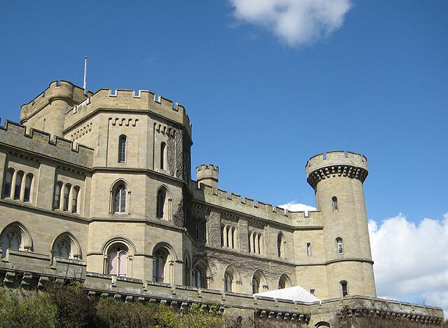 A large, historic stone castle with multiple towers and arched windows.