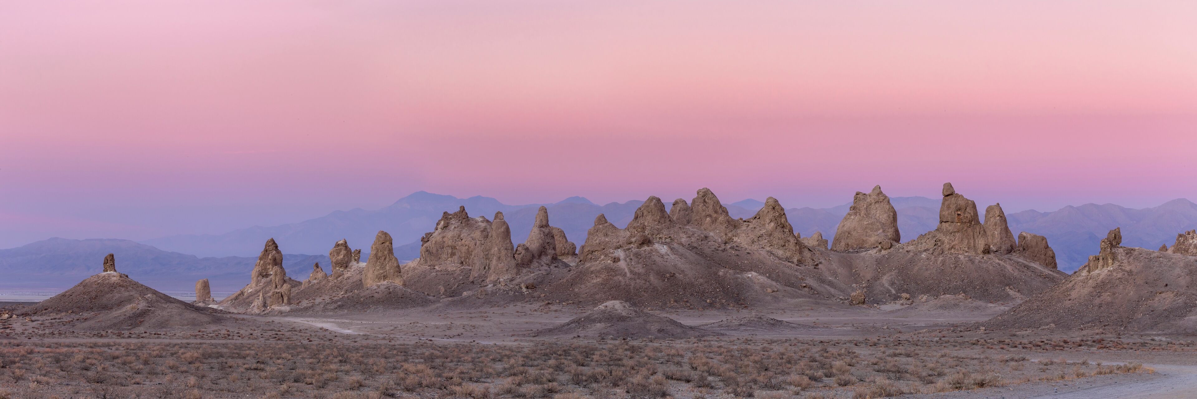 A desert landscape with unique rock formations and distant mountains.