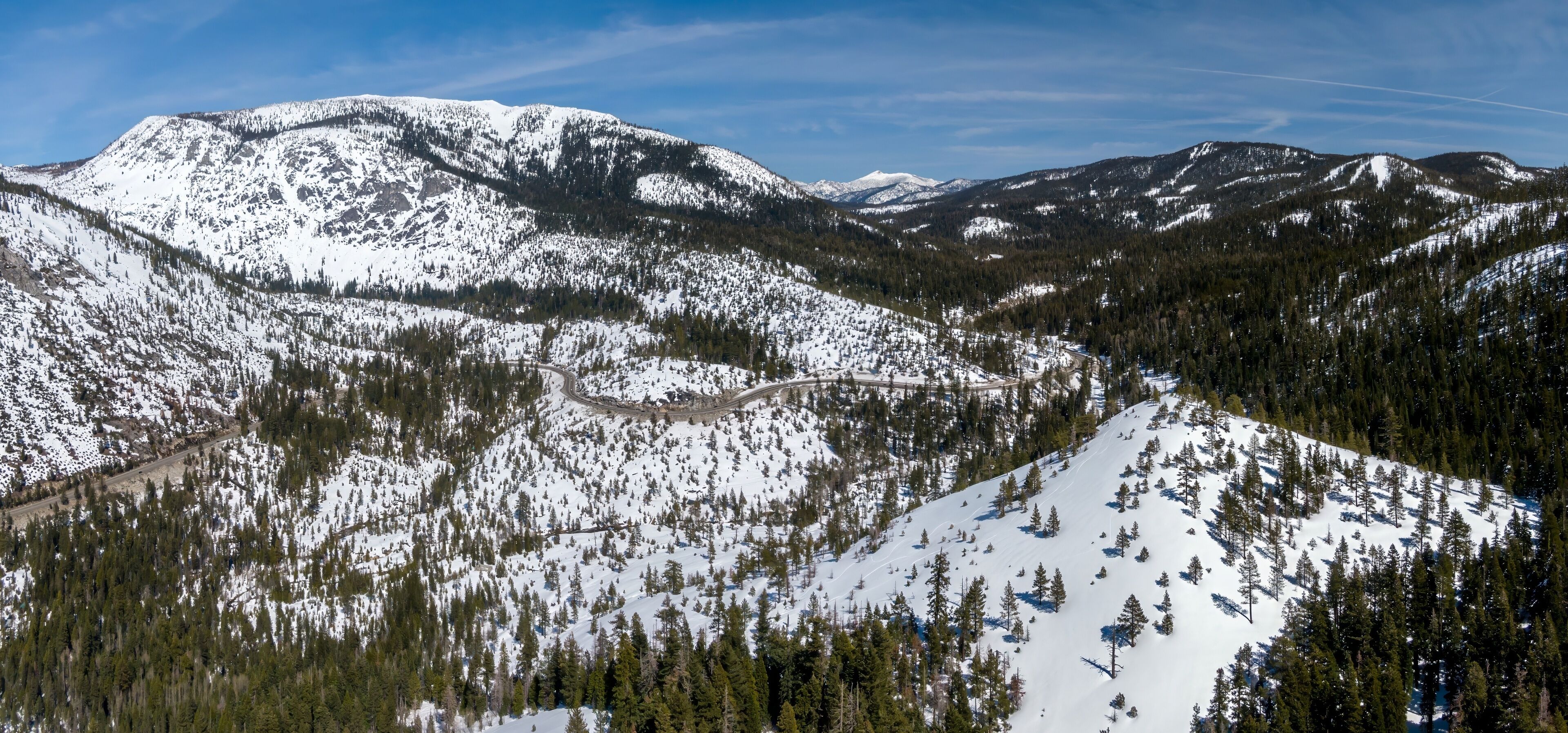 Aerial: Snow covered Mountains and forest in the sierra Nevada ranges Twin Bridges, California, United States of America.