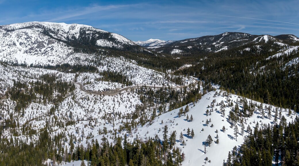 Aerial: Snow covered Mountains and forest in the sierra Nevada ranges Twin Bridges, California, United States of America.