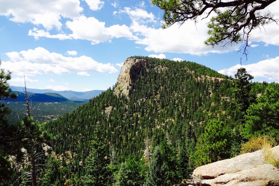 A mountain with dense forests and a clear sky.
