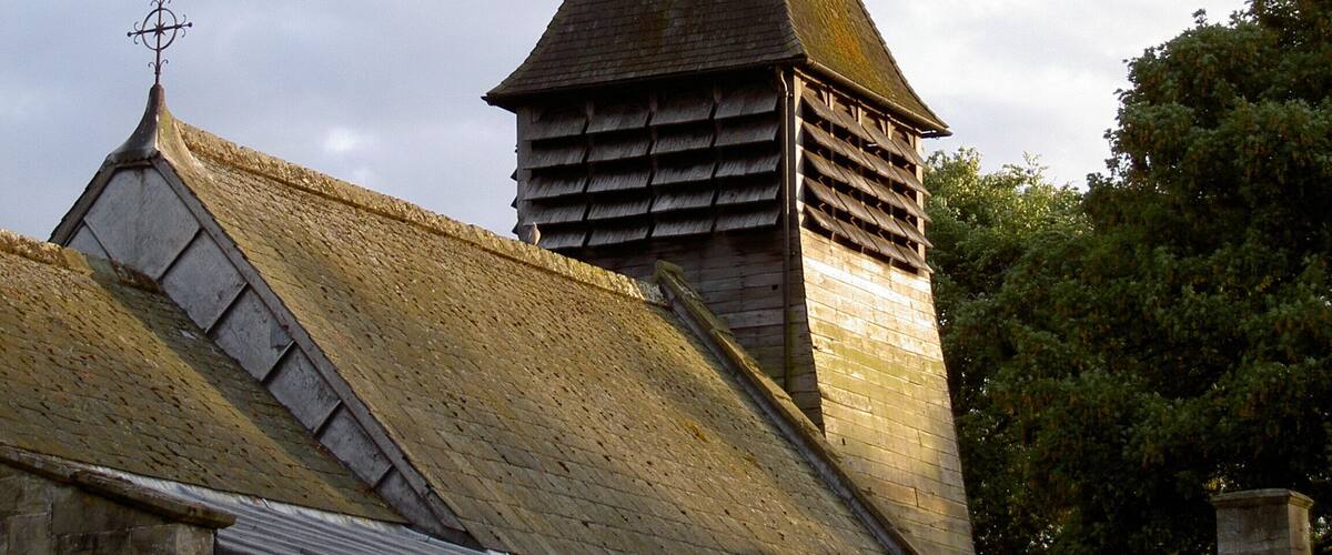 A church with a pointed steeple and a weather vane.