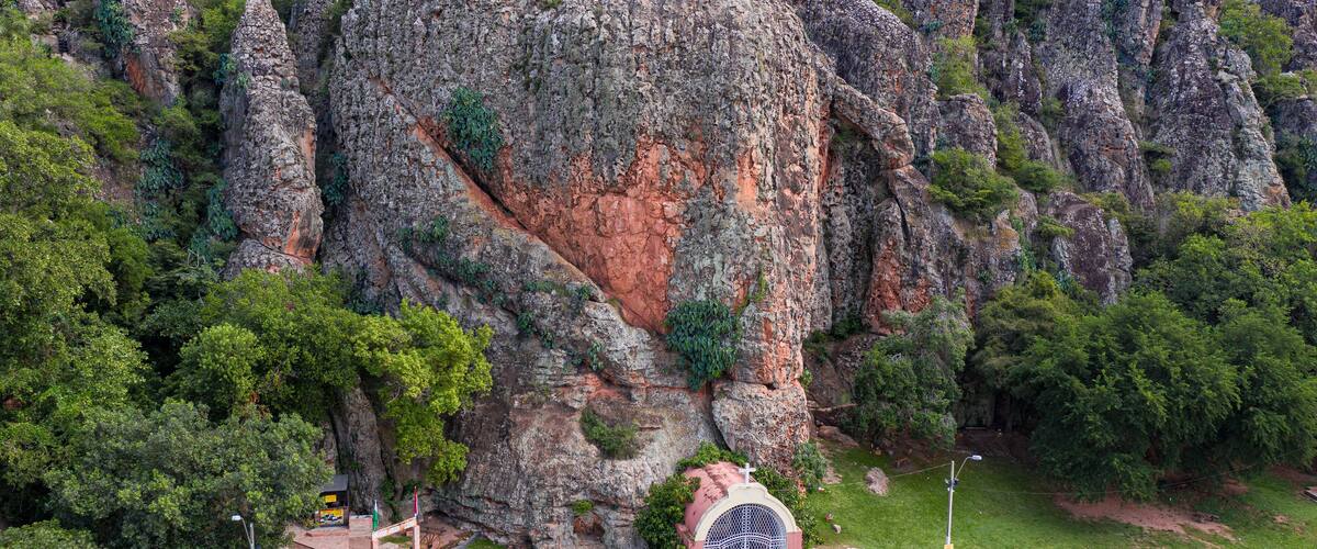 A rocky mountain with a small chapel at its base.