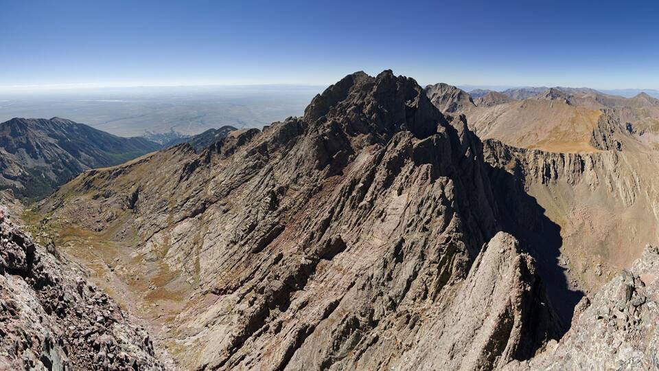 A rugged mountain range with sharp peaks and rocky terrain.