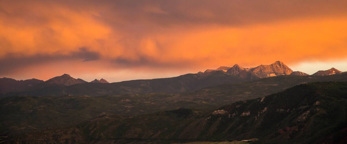 A mountain range with a dramatic sunset sky.