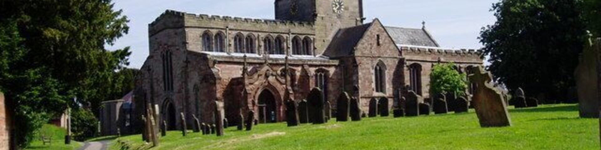 Una iglesia con una torre alta y ventanas en arco.