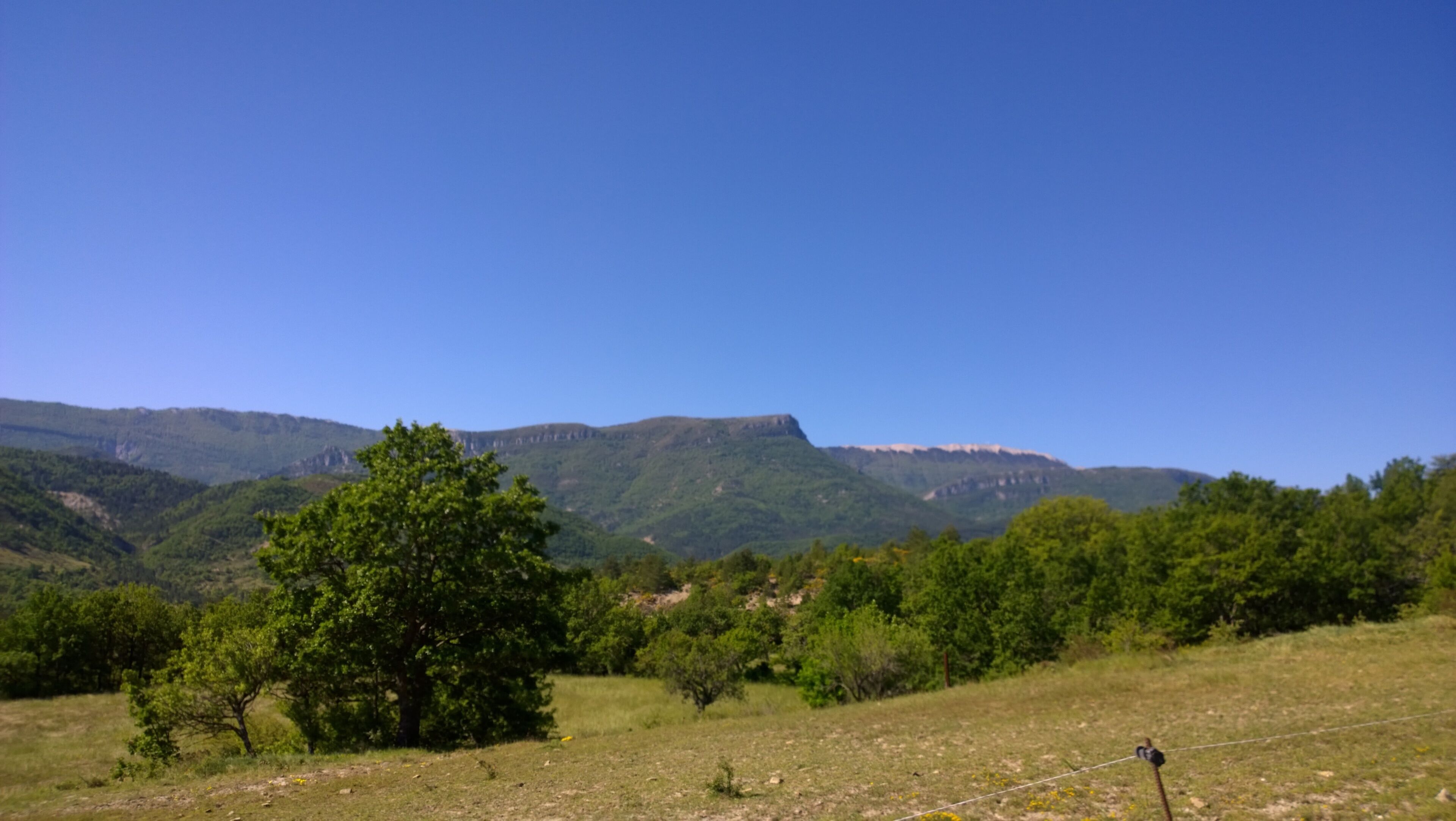 A mountainous landscape with a clear blue sky.