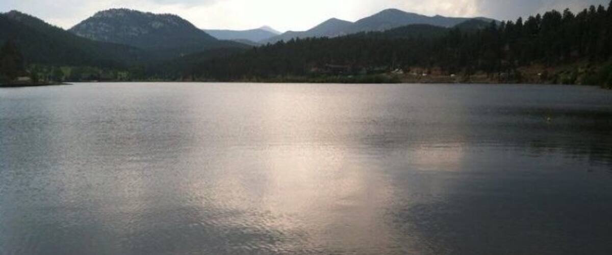 A calm lake surrounded by mountains.