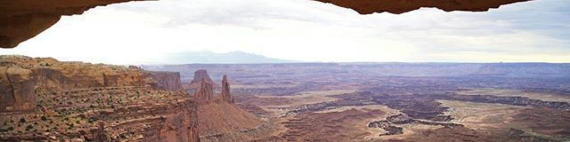 Paisaje de cañón con una formación rocosa destacada en lo alto.
