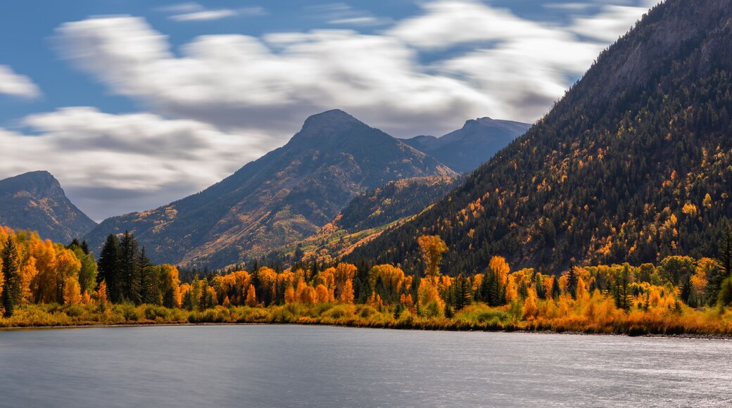 Fast Moving Clouds Over Marble Lake Colorado Autumn Landscape Scene. Bright Blue Sunny Sky with Clouds Over Yellow Aspen Trees.