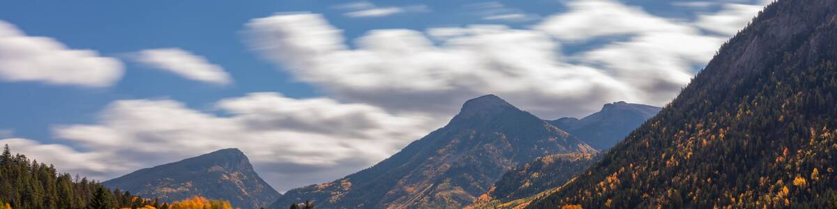 Fast Moving Clouds Over Marble Lake Colorado Autumn Landscape Scene. Bright Blue Sunny Sky with Clouds Over Yellow Aspen Trees.