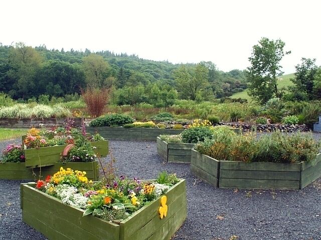 Leswalt Community Garden A very pleasant garden, consisting mainly of raised beds. It is managed by the Leswalt Community Association, with the involvement of several youth groups. Two colourful boxes in this view have logos for the Rainbows and Brownies. For more information see the garden's website - http://www.leswaltwetlandgarden.org.uk/index.html .
