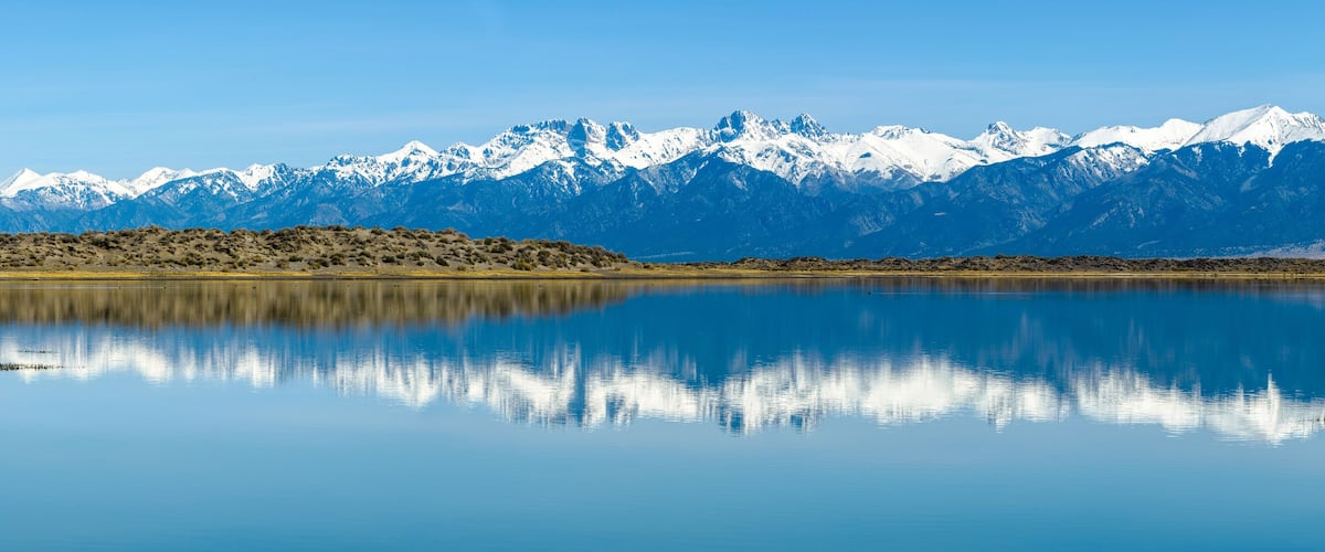 Sangre de Cristo Mountains - Panoramic view of Snow-capped Sangre de Cristo Mountains, reflecting in San Luis Lake. Colorado, USA.