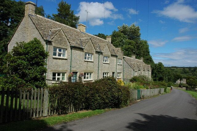 Houses at Yanworth Cotswold stone built houses near Yanworth church, the tower of which can be seen in the background.