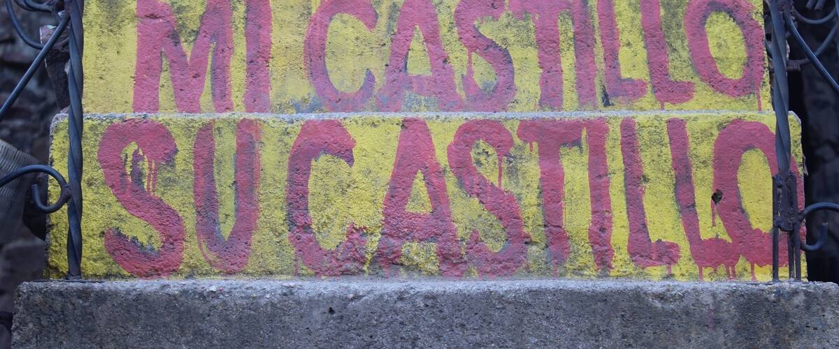 A yellow sign with red text on a concrete staircase.