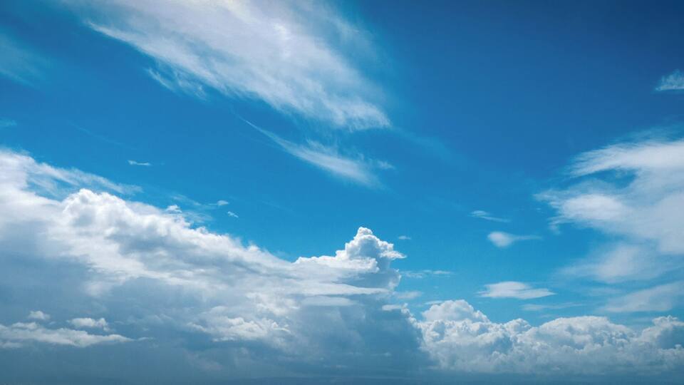 A clear blue sky with scattered clouds.