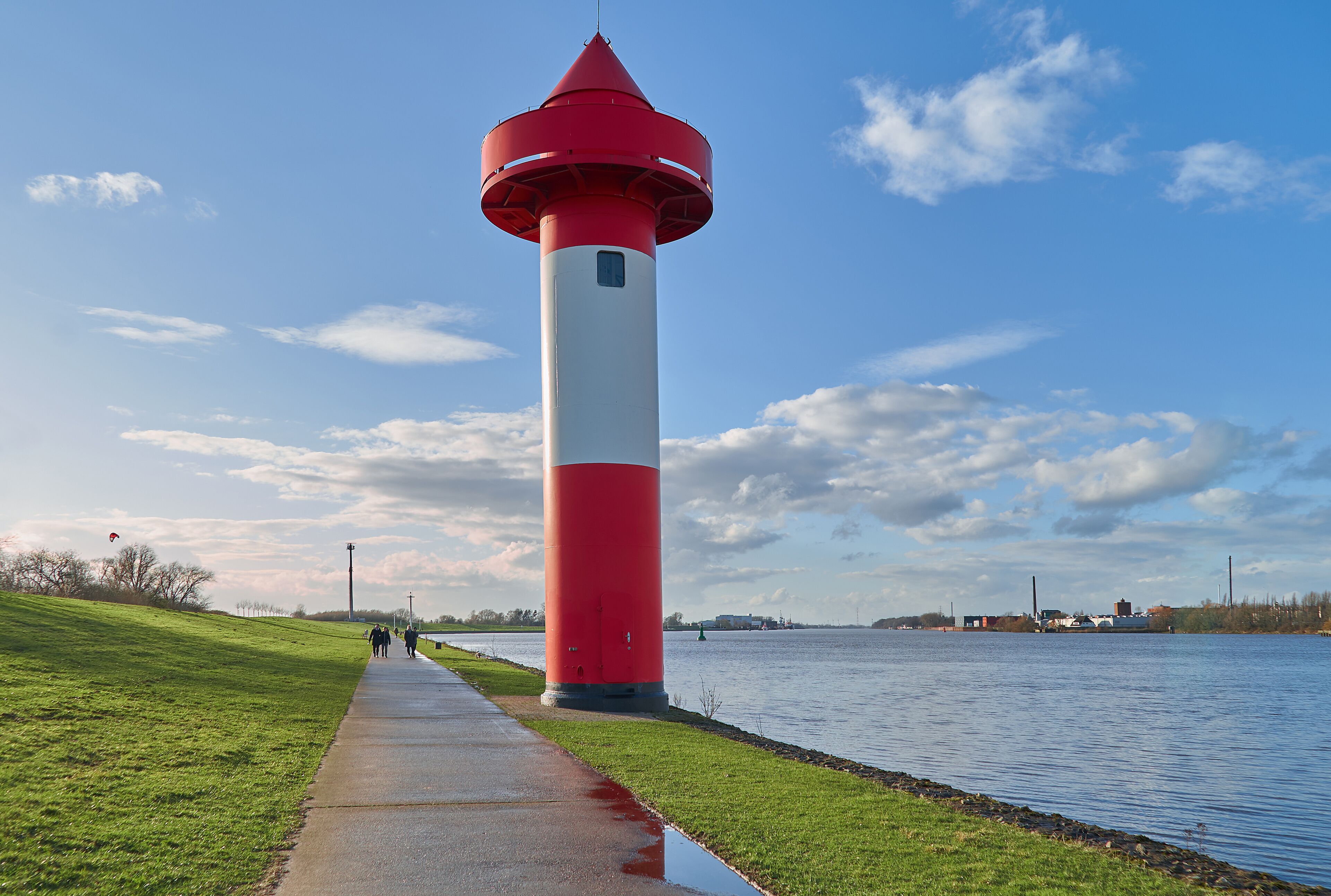 small lighthouse at Ritzenbütteler Sand, municipality Lemwerder (district Wesermarsch, Germany) next to the river Weser on a sunny spring day with vivid blue sky and clouds