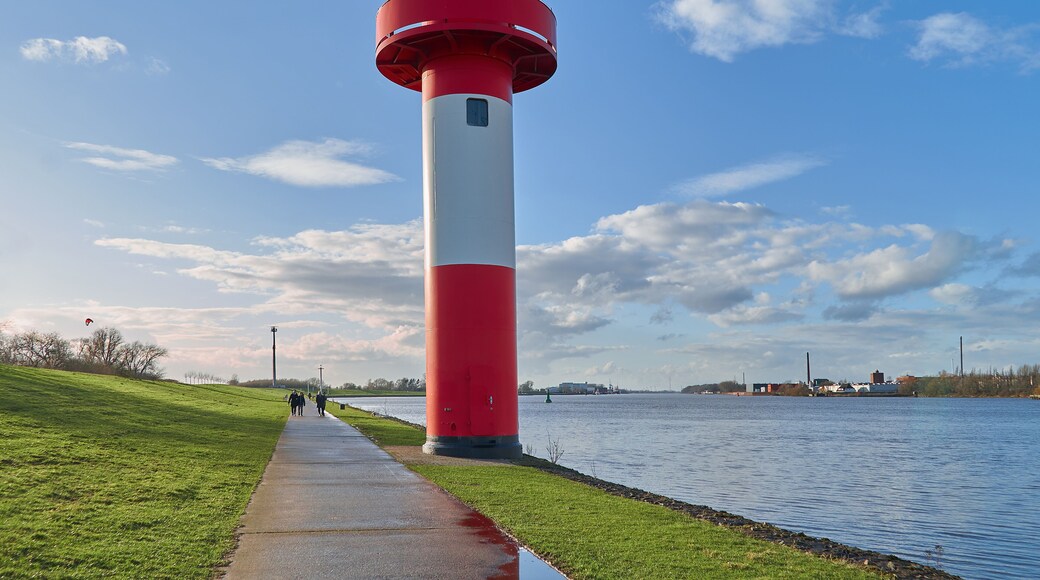 small lighthouse at Ritzenbütteler Sand, municipality Lemwerder (district Wesermarsch, Germany) next to the river Weser on a sunny spring day with vivid blue sky and clouds