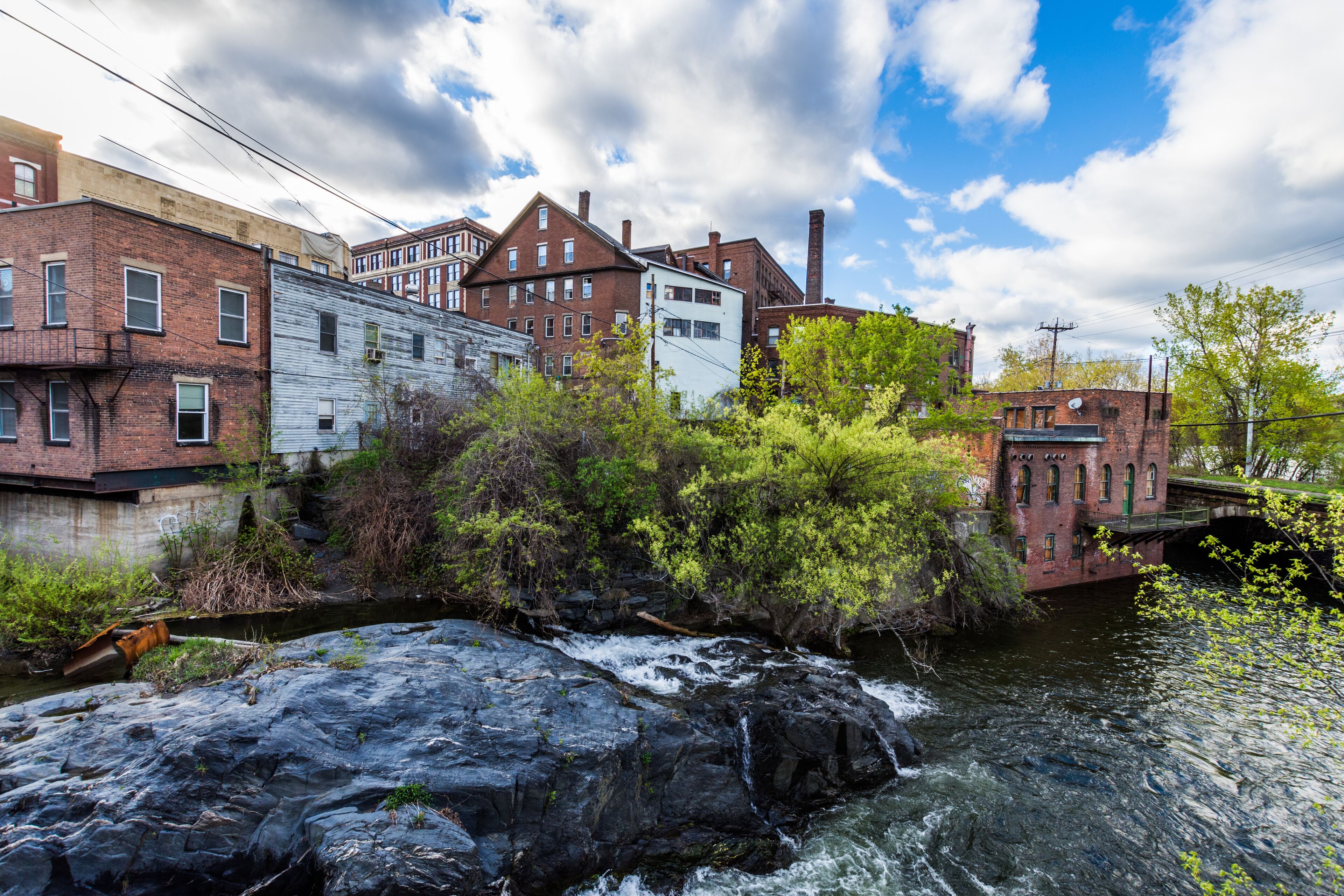 A river flowing through an urban area with historic buildings and a bridge.