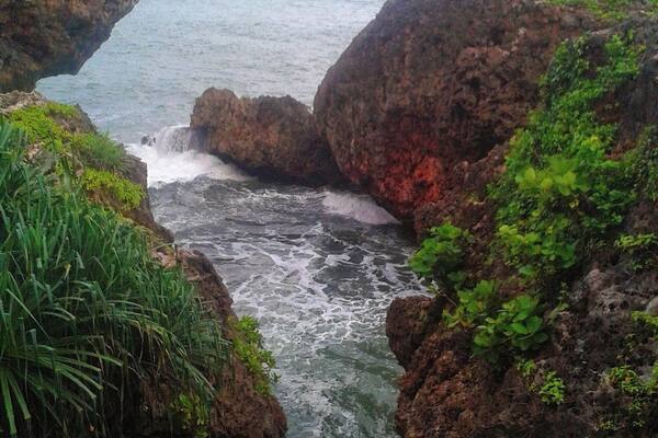 A coastal landscape with rocky cliffs and a narrow waterway.