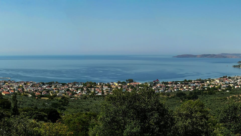 A coastal town with a view of the sea and hills.